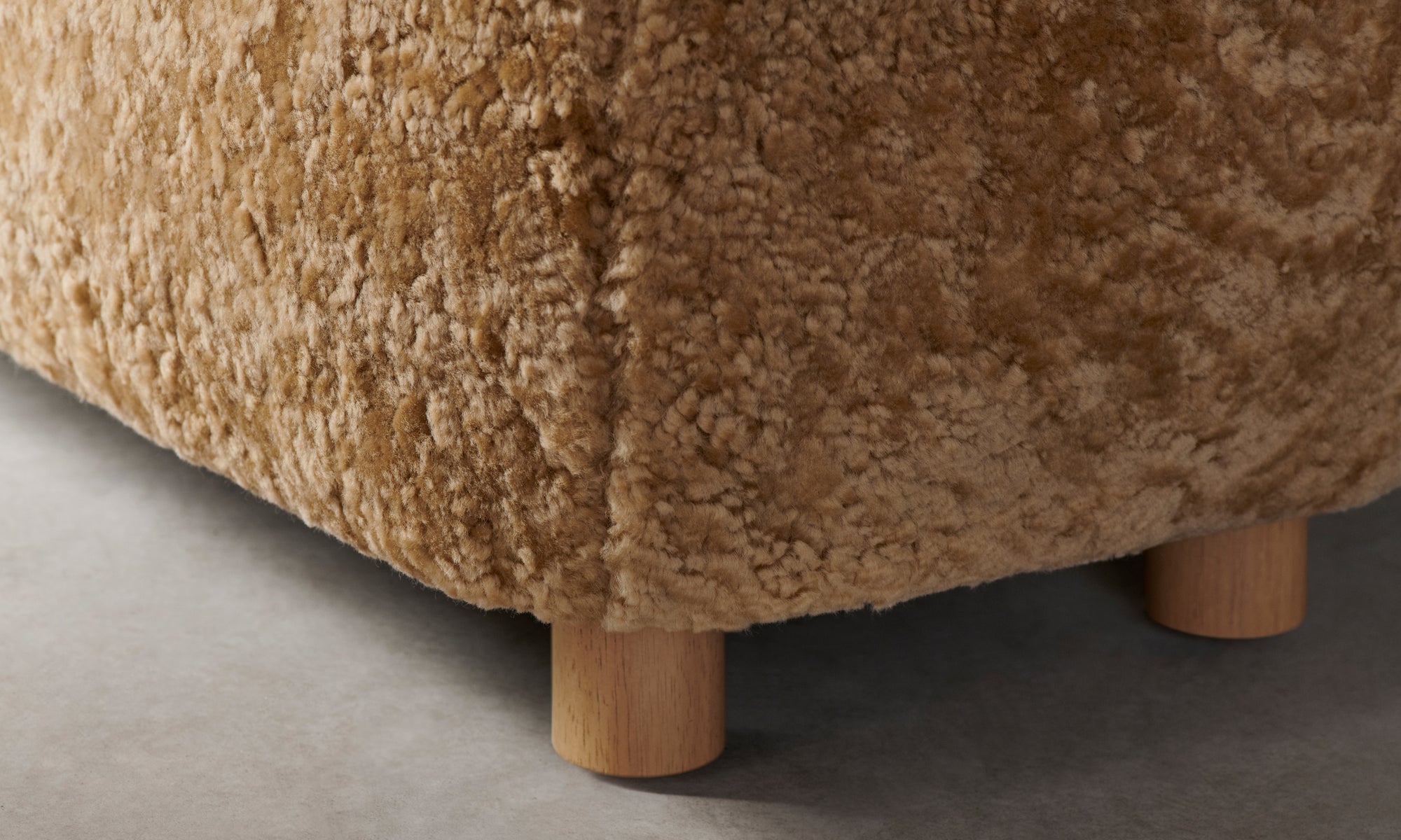 perry bench in brown shearling with wooden legs, close up