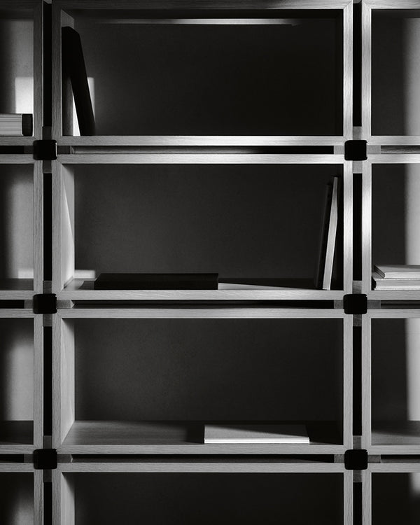 Detail of the Vento Bookshelf's wood grid structure and glass joinery, in black and white.