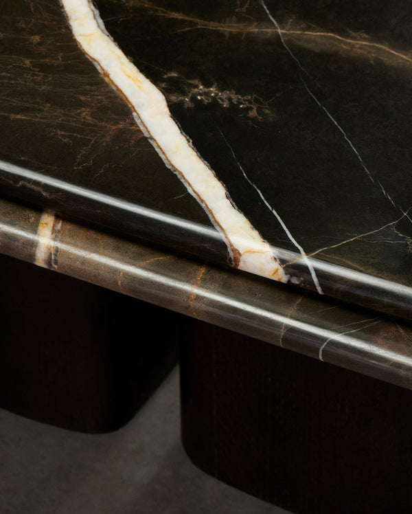 Close-up of Brio Coffee Table showcasing the dark stone coffee table corner with veined black-and-gold marble and a brass edge inlay.