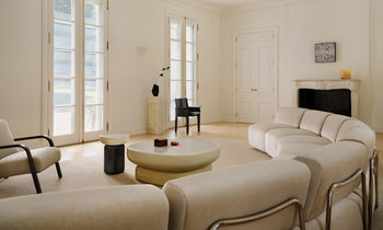 miles curved modular sectional in beige mohair and an glass coffee table in a modern french living room