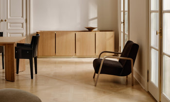 leon black lacquered dining armchair and a brown mohair accent chair in a modern french dining room