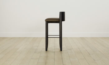 delancey barstool in black ash wood with truffle green leather seat with curved back, side view