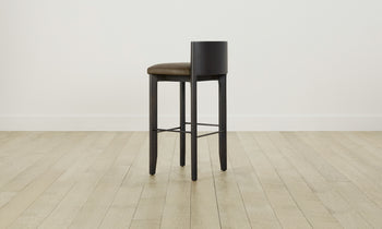 delancey barstool in black ash wood with truffle green leather seat with curved back, angle view