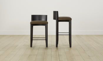 delancey barstools in black ash wood with truffle green leather seat with curved back