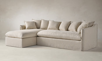 dune sectional sofa with chaise in beige linen with throw pillows - angle view