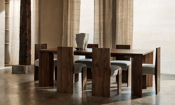 garrett dining chairs in brown walnut wood and grey boucle fabric in a modern dining room