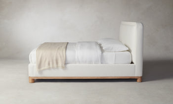 kent bed with upholstered frame and headboard in white linen with wood trim - side view