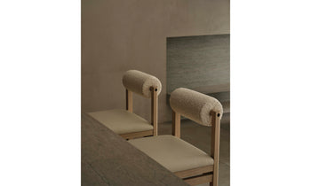 thayer wood barstool in oak with white leather seat and boucle bolster back in a modern room