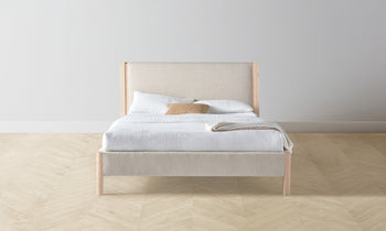 thomson upholstered bed in beige linen with ash wood legs - front view