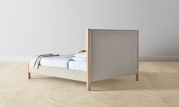 thompson upholstered bed in beige linen with ash wood legs - back view