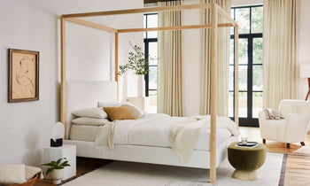 thompson canopy bed upholstered in white boucle with ash wood trim - in a modern bedroom